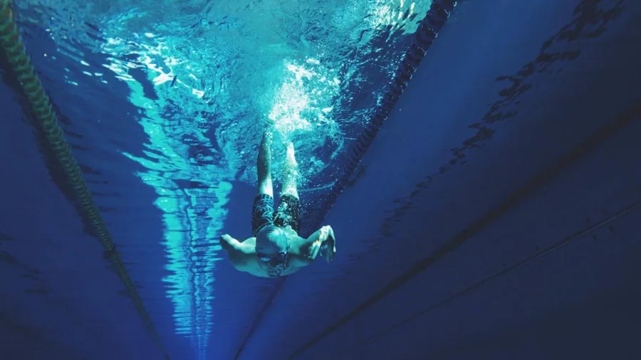 A swimmer diving underwater in a pool