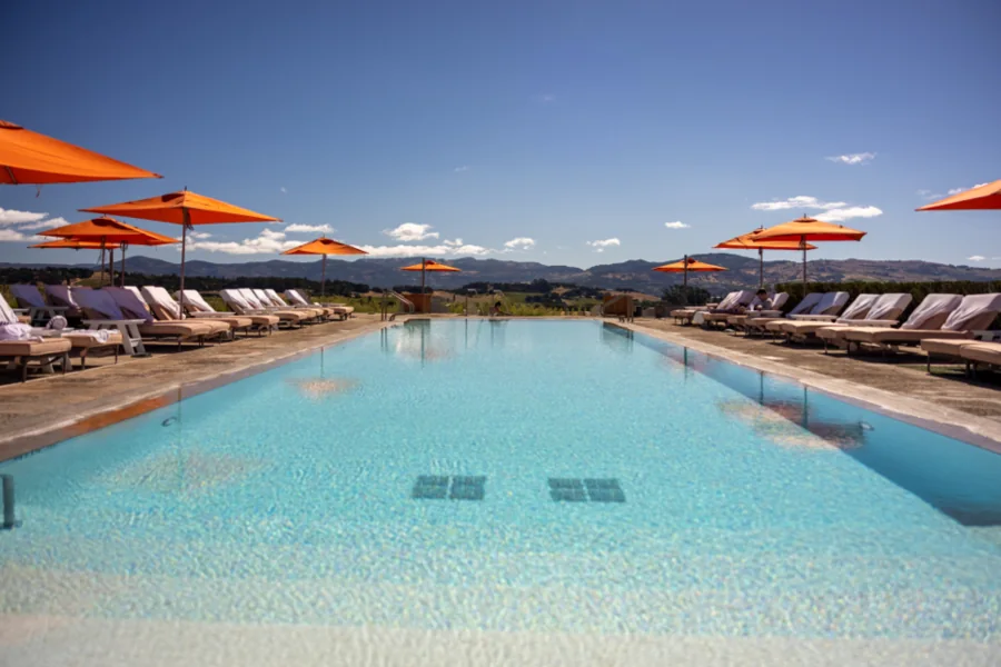 A long outdoor pool with loungers and umbrellas